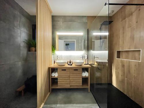 une salle de bain avec deux lavabos et un miroir dans l'établissement Villa Plénitude, à BIQ