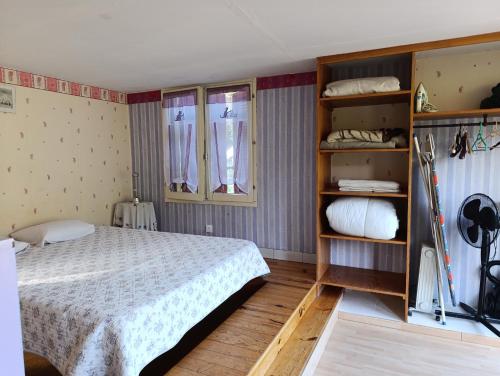 - une chambre avec un lit et quelques étagères dans l'établissement Gite des Suvieres, à Les Mayons
