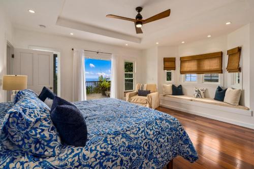 een slaapkamer met een blauw en wit bed en een bank bij Hualalai in Kailua-Kona