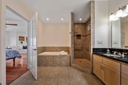 een badkamer met een bad, een douche en een wastafel bij Hualalai in Kailua-Kona