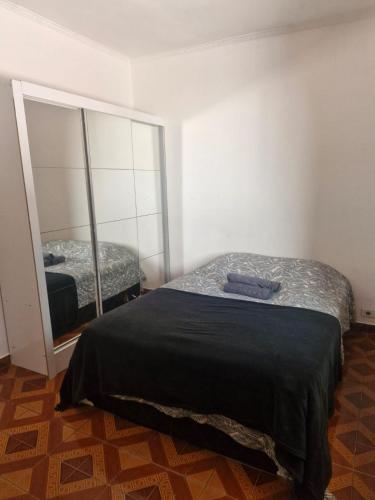 a bedroom with a bed and a large mirror at Aurora um in Guarulhos