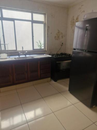 a kitchen with a stainless steel refrigerator and a window at Aurora um in Guarulhos