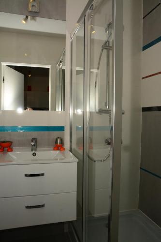 a white bathroom with a shower and a sink at Apartamenty Bursztynowe w Kołobrzegu Sun&Relax in Kołobrzeg
