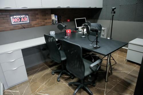 an office with a desk with two chairs and a computer at eSuites Sorocaba in Sorocaba