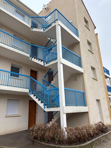 un bâtiment avec des escaliers bleus sur son côté dans l'établissement Appartement proche mer, à Cucq