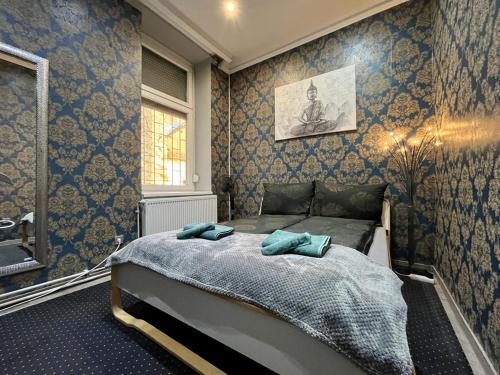 a bedroom with a bed with blue wallpaper at JohnGold Buddha Room in Debrecen