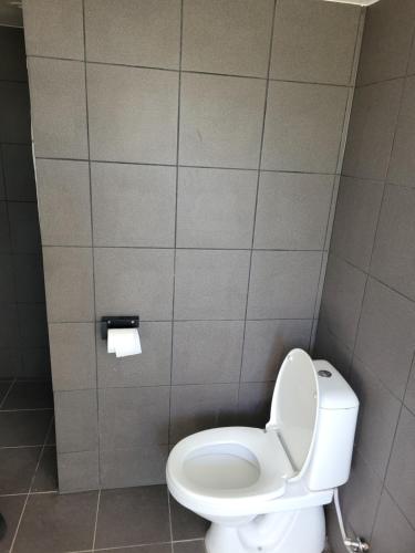 a bathroom with a toilet in a tiled wall at Lejbølle Gamle Bageri in Tranekær