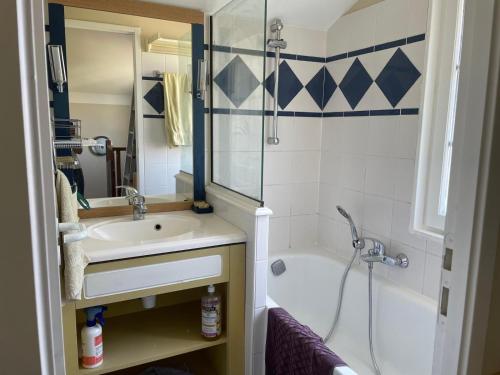 ein Badezimmer mit Waschbecken, Dusche und Badewanne in der Unterkunft La Petite Maison bleu in Talmont