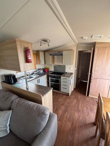 a kitchen and living room with a couch and a table at The Lookout 3 Bedroom Family Caravan with Sea View Pet Friendly in Aberystwyth