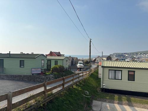a row of houses on the side of a road at The Lookout 3 Bedroom Family Caravan with Sea View Pet Friendly in Aberystwyth