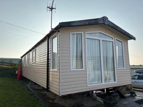 a tiny house on a stand in a yard at The Lookout 3 Bedroom Family Caravan with Sea View Pet Friendly in Aberystwyth