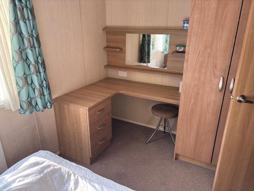 a desk with a mirror and a chair in a room at The Lookout 3 Bedroom Family Caravan with Sea View Pet Friendly in Aberystwyth
