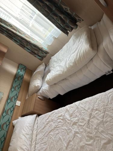 a bedroom with two bunk beds and a window at The Lookout 3 Bedroom Family Caravan with Sea View Pet Friendly in Aberystwyth