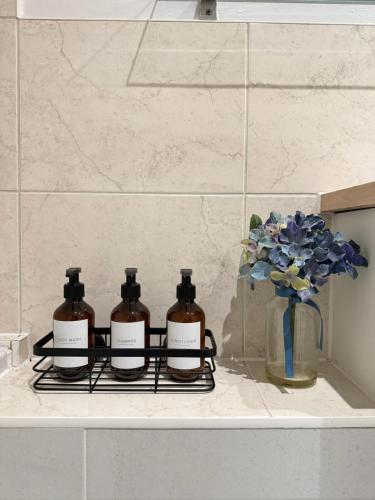 three bottles of soap on a rack in a bathroom at Modern Apartment - Free Parking in London