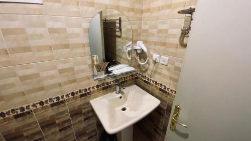 a bathroom with a sink and a mirror at Quel Serviced Units in Taif