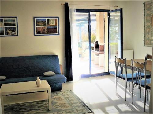 un salon avec un canapé bleu et une table dans l'établissement La maison bleue, à Cadenet