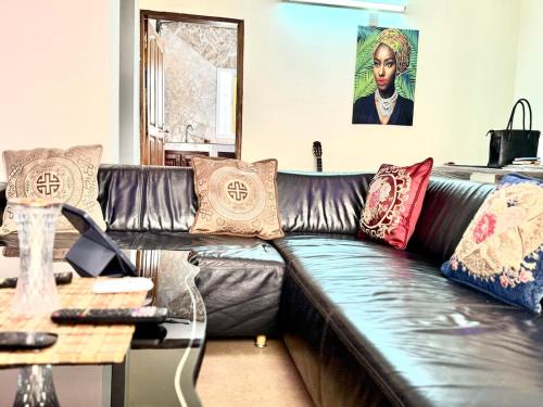 a leather couch with pillows on it in a living room at Santa-Barba brand new apart Yde in Yaoundé