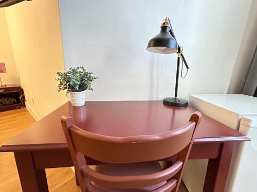 a wooden desk with a lamp and a plant on it at Hotel La Residence du Voyageur in Montréal