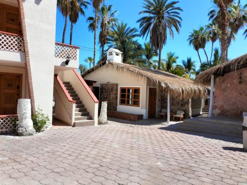 a house with palm trees and a driveway at Sandy Shores Cabaña 8A in La Paz