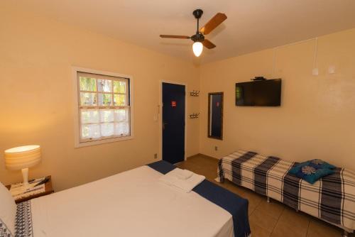 a bedroom with two beds and a flat screen tv at Pousada Estrada Das Águas, São João del Rei in São João del Rei