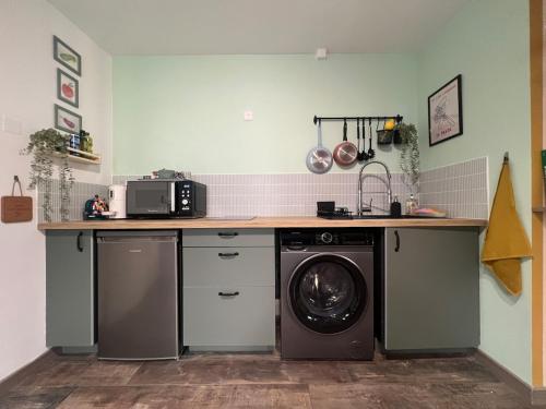une cuisine avec une machine à laver sous un comptoir dans l'établissement Cozy studio in Menton old town - near parking, à Menton