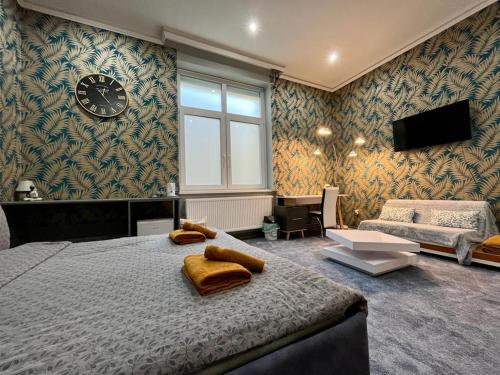 a bedroom with a large bed and a clock on the wall at JohnGold Gold Room in Debrecen