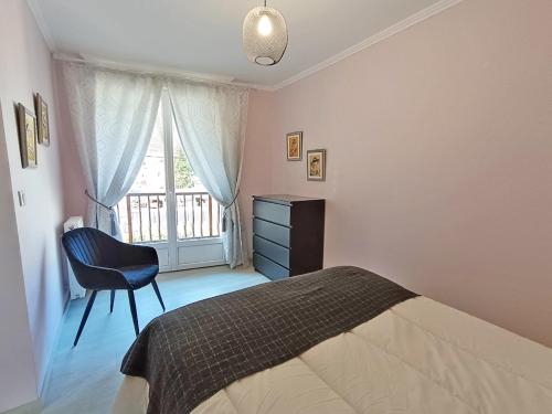 une chambre avec un lit, une chaise et une fenêtre dans l'établissement Chez Céleste, Luchon centre, T2 bis, 4 personnes, à Luchon
