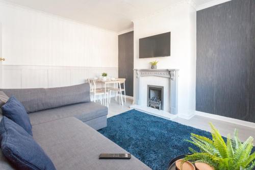 a living room with a couch and a fireplace at Warrington House, driveway parking & WiFi! in Warrington