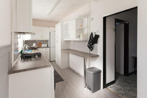 a kitchen with white cabinets and a counter top at Warrington House, driveway parking & WiFi! in Warrington