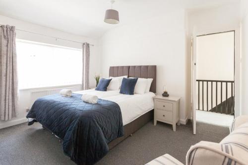 a bedroom with a large bed with blue pillows at Warrington House, driveway parking & WiFi! in Warrington