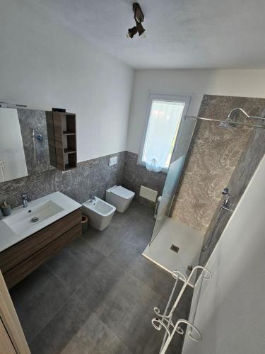 a bathroom with a sink and a toilet and a mirror at Vintage Village B&B in Alghero