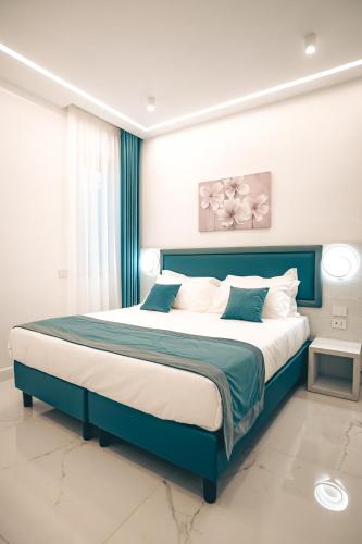 a bedroom with a large bed with a blue headboard at Villa Florisia in Gragnano