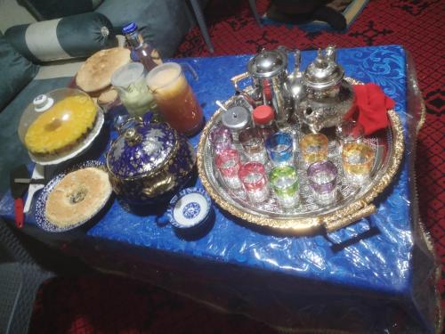 a blue table with a tray of glasses and a tea pot at almou auberge imilchil in Imilchil