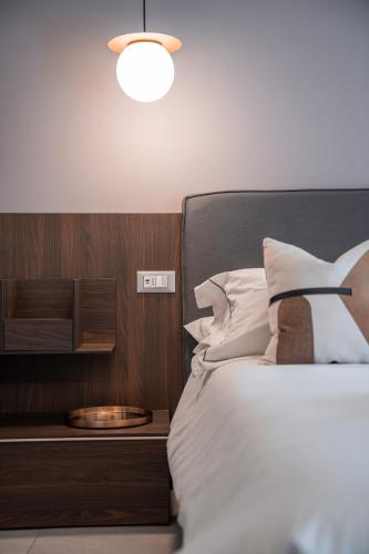 a bedroom with a bed with a nightstand next to it at ES Rooms and Apartments in Nago-Torbole