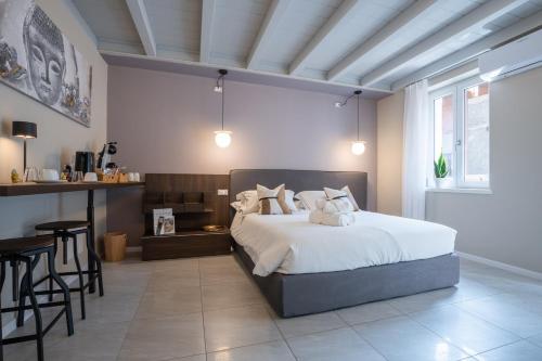 a bedroom with a large bed and a table at ES Rooms and Apartments in Nago-Torbole