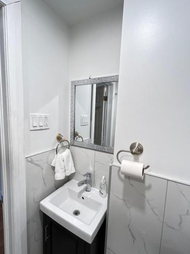 a white bathroom with a sink and a mirror at Hotel La Residence du Voyageur in Montréal