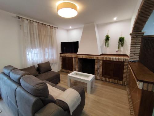 a living room with a couch and a fireplace at Casa Abuela Encarna in Hornachuelos