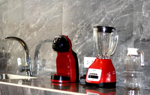 a red blender sitting on a counter next to a sink at 4SA Apartamentos Estudio Ejecutivos in Cajamarca