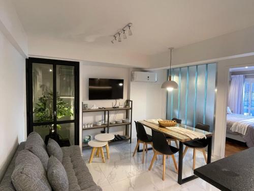 a living room with a couch and a dining room table at DEPARTAMENTO CENTRICO CON COCHERA - CORDOBA Argentina- in Cordoba