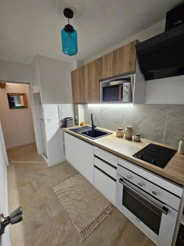 a kitchen with a sink and a microwave at Vue mer exceptionnelle, Calme & tout confort, plage à pied in Le Gosier