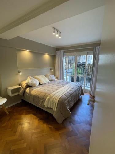 a bedroom with a bed and a large window at DEPARTAMENTO CENTRICO CON COCHERA - CORDOBA Argentina- in Cordoba