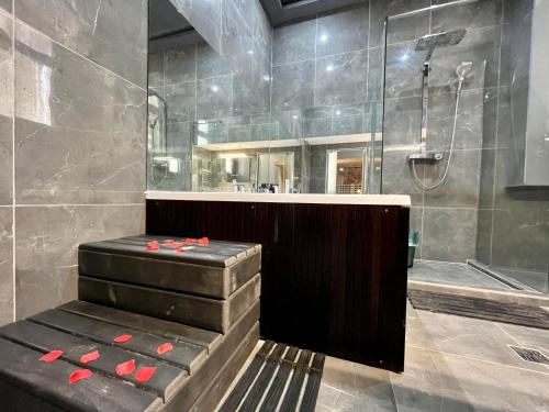 a bathroom with a shower and a bench with red roses at JohnGold Wellness Room in Debrecen