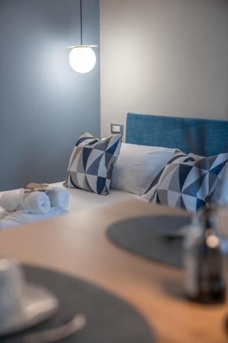 a bed with blue and white pillows on it at ES Rooms and Apartments in Nago-Torbole