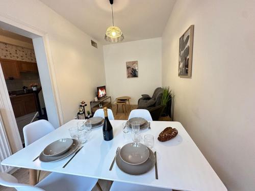 - une table blanche avec des assiettes et des verres à vin dans l'établissement S Au détour de la meuse Maison 2 Chambres au centre, à Revin