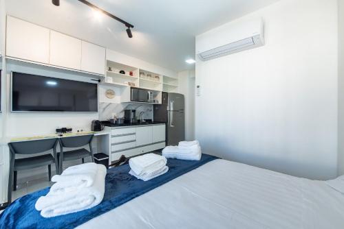 ein Schlafzimmer mit einem Bett mit weißen Handtüchern darauf in der Unterkunft "1103 - Studio Moderno e Completo no Campo Belo!" in São Paulo