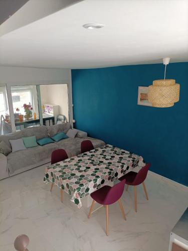 un salon avec une table avec des chaises et un canapé dans l'établissement Maison spacieuse de 2 chambres avec cour, au Tréport