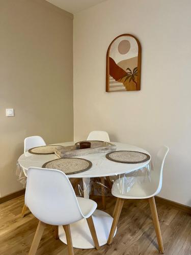 une table avec quatre chaises et un miroir mural dans l'établissement Elegant apartment, à Valenciennes