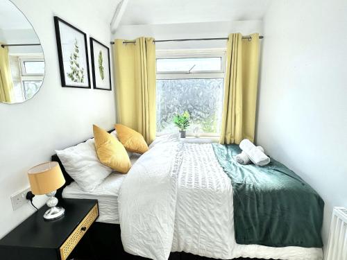 a bedroom with a bed and a window at 3 bedroom entire house sleeps 8 twin beds near Coventry University City Center driveway Parking in Coventry