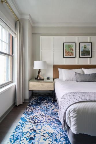 a bedroom with a bed and a blue rug at Heathman Hotel in Portland