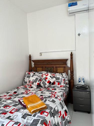a bedroom with a bed with a checkered comforter at Adem Cozy Home in Abu Dhabi